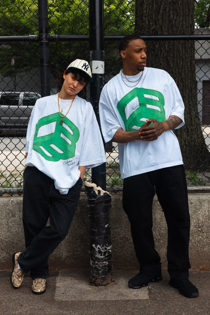 Two models wearing white CHILLBAEBEEE Men's Tees with green CBB logo, standing outdoors by a chain-link fence